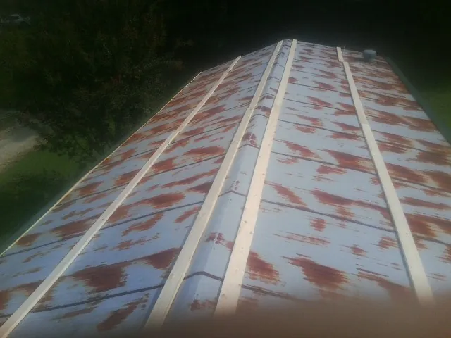 Rusted metal roof panels with new wood purlins before replacement — Storm Damage Roof Repair in Fields by Roofing Brothers