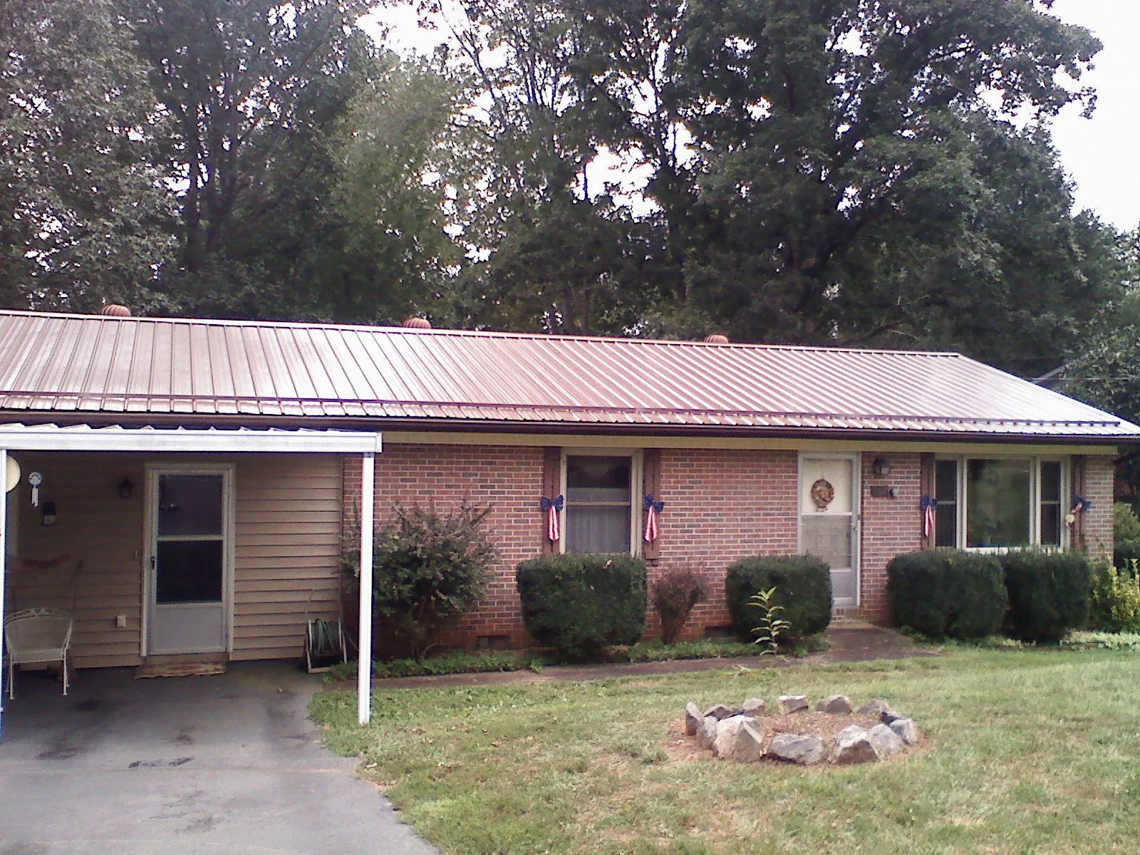 Bronze metal roof and carport on a brick ranch home — Roof Repair work by our crew in Fields